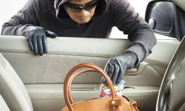 Se descuida mujer y le roban el bolso del vehículo