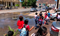 Niños aprenden en medio de río de drenaje